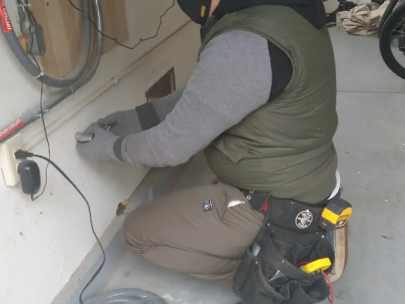 Electrician performing outlet wiring in a Billings garage